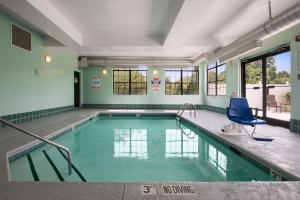海波因特温德姆集团温盖特高点酒店的大楼内带蓝色椅子的游泳池