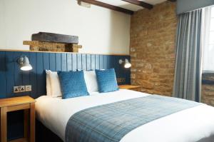 班伯里Red Lion Hotel by Greene King Inns的一间卧室配有一张带蓝色枕头的大床