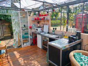 HankVrijstaande accommodatie Glamping de Kas InN的温室里的厨房,配有水槽和柜台