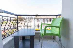 伊兹密尔YAŞAM HOTEL的阳台的绿色椅子和桌子
