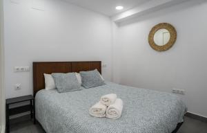 多列毛利诺斯APARTAMENTOS EL CARMEN Carihuela PLAYA的一间卧室配有带毛巾的床