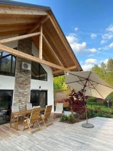 戈德马图杰克Alpine Wooden Villa with a View的庭院配有桌椅和遮阳伞。