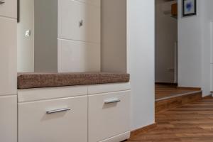 马里博尔SEDAMI的厨房铺有木地板,配有白色橱柜。