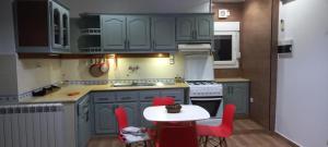 阿尔及尔Alger Draria f2的厨房配有蓝色橱柜和红色椅子的桌子