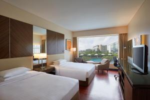 孟买孟买国际机场万豪度假酒店的酒店客房设有两张床和一台平面电视。
