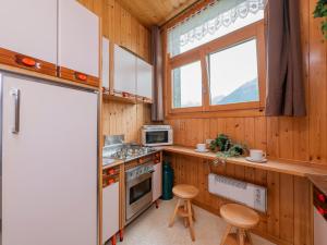 PiattaI Host Apartment - Centrale 18 - Bormio的厨房配有冰箱和炉灶。 顶部烤箱
