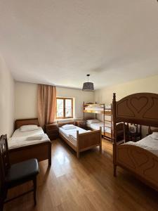瓦勒博内Hostel Quku i Valbones的一间带三张双层床和一张沙发的卧室