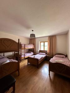 瓦勒博内Hostel Quku i Valbones的客房设有三张双层床和一扇窗户。