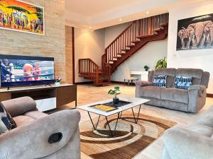 达累斯萨拉姆Fairview Luxury Apartments的客厅配有两张沙发和一台电视机
