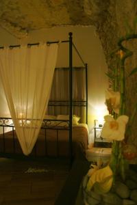 阿姆博斯Chambres d'Hôtes Troglodytes Le Clos de L'Hermitage的一间卧室配有带花朵的天蓬床