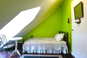 Santa RosaMadie's Place Bed & Breakfast in Santa Rosa, Laguna near Enchanted Kingdom的一间卧室设有绿色的墙壁和一张床