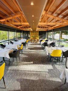 安道尔城安道​​尔公园酒店的用餐室配有桌子和黄色椅子