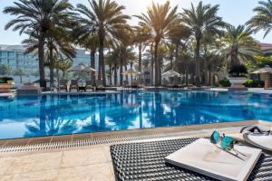 阿布扎比爱尔拉哈海滩酒店的度假村内一座种有棕榈树的大型游泳池