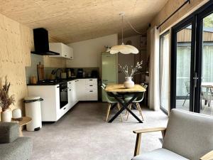 洪德洛FIKA Luxe vakantiewoning voor 4 personen @ Veluwe的厨房以及带桌子的用餐室。