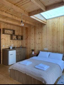 Kʼveda ChʼkhutunetʼiHouse in mountains, near Batumi- Lemanor Lodge的一间带一张大床的卧室,位于带木墙的房间