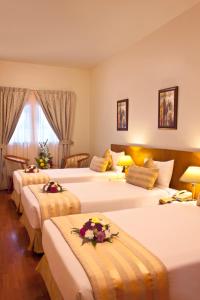 迪拜地标广场酒店的酒店客房,配有三张带鲜花的床
