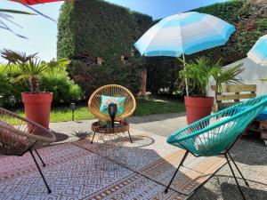 梅斯Campanile Metz Est Technopole - Restaurant的庭院配有两把椅子和一把遮阳伞