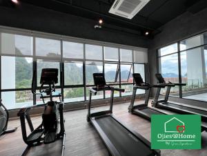 淡文Ojies Home Sunway Onsen Suites 2BR Theme Park View的一间健身房,里面设有三台跑步机,房间设有窗户