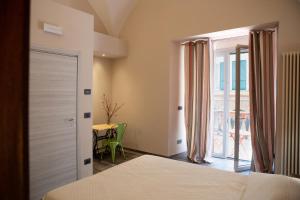 热那亚Le Caravelle Affittacamere的一间卧室设有一张床、一个窗口和一张桌子