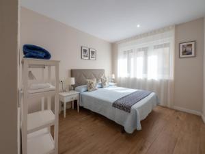 奥维多Apartantiguo San Isidoro10的白色的卧室设有床和窗户