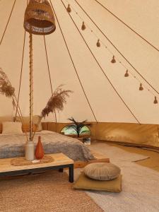 Amberhouse Glempings的带帐篷、床和桌子的客房