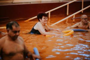 伯伊莱图什纳德Hotel Tusnad的一群人,在水中,有冲浪板