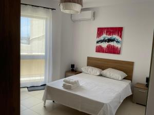比尔基卡拉Privilege suits Swatar的卧室配有白色的床和墙上的绘画作品