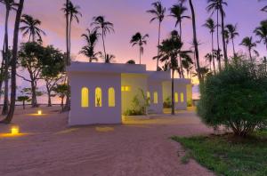 吉汶瓦Diamonds Mapenzi Beach的棕榈树海滩上的房子