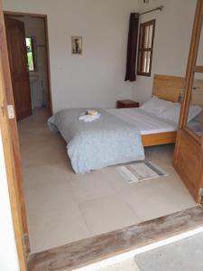 斯基灵角la maison de la fontaine的卧室配有1张床,铺有瓷砖地板。