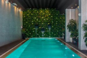 拉巴特The View Rabat的一座建筑中带绿色墙的室内游泳池