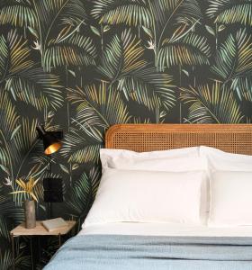 切尔维亚Antica Dimora Le Misure的一间卧室配有一张带热带壁纸的床