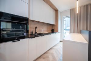 罗兹Apartament Piotrkowska 44 - studio的厨房配有白色橱柜和水槽