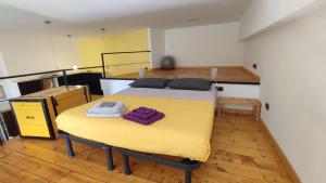 米兰la casa di amy - loft corvetto的配有床和黄色桌子的房间
