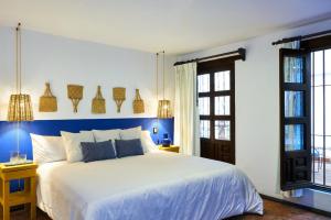 墨西哥城AmazINN Places Casa Coyoacan的卧室配有白色床、蓝色的墙壁和窗户
