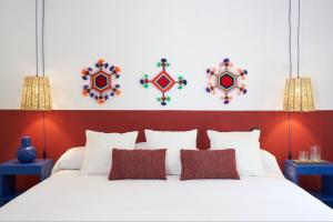 墨西哥城AmazINN Places Casa Coyoacan的卧室配有一张白色大床和红色床头板