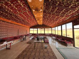 瓦迪拉姆Salameh's Bedouin Camp的大型客房设有桌椅和窗户。