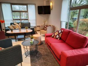 梅斯Campanile Metz Est Technopole - Restaurant的客厅配有红色的沙发和桌子