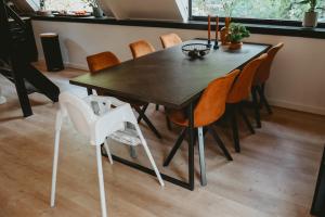 拉纳肯Boshuisje Rekem - Topo的黑色餐桌,带橙色椅子