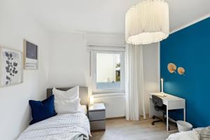 居特斯洛Großzügige & Moderne Wohnung - Wifi - Terrasse的一间卧室配有一张床、一张书桌和一个窗户。