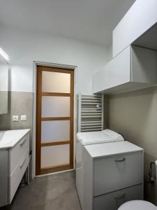 旺斯Charmant Studio avec terrasse et parking à Vence的厨房配有白色的柜台和木门。