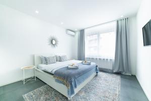 贝尔格莱德Belgrade CITY CENTER Apartments的白色的卧室设有床和窗户
