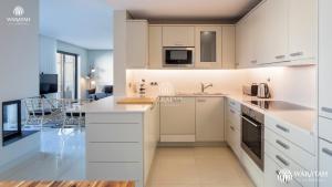 韦尔都勒博Apartment Micaela的一间带白色橱柜的厨房和一间客厅