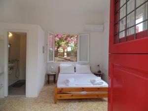 KhlóïFishermans House的一间卧室设有一张床和一扇红色的门