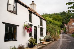 Compton MartinWoodview - cosy 1840s cottage in Chew Valley and Mendip AONB的白色的房子,有黑色的窗户和鲜花