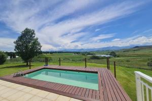 安德伯格25 Hazyview Drakensburg Mountain Views的围栏旁甲板上的游泳池