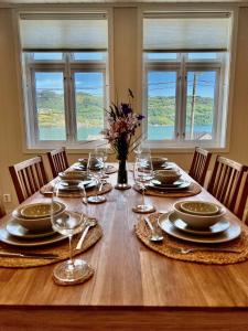 厄于斯特瑟Hardangerfjord View - luxury fjord-side holiday home的餐桌,配有盘子和酒杯