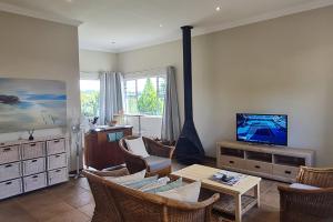 安德伯格25 Hazyview Drakensburg Mountain Views的客厅配有电视和桌椅