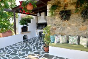 纳克索乔拉Ktima Dimitrios的庭院设有长凳和石墙,配有枕头。