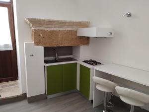 梅萨涅Petra Rossa Affittacamere的一个带绿色橱柜和水槽的小厨房