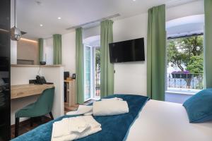 里耶卡Ribica Luxury Rooms的一间卧室配有一张床、一张书桌和一个窗户。